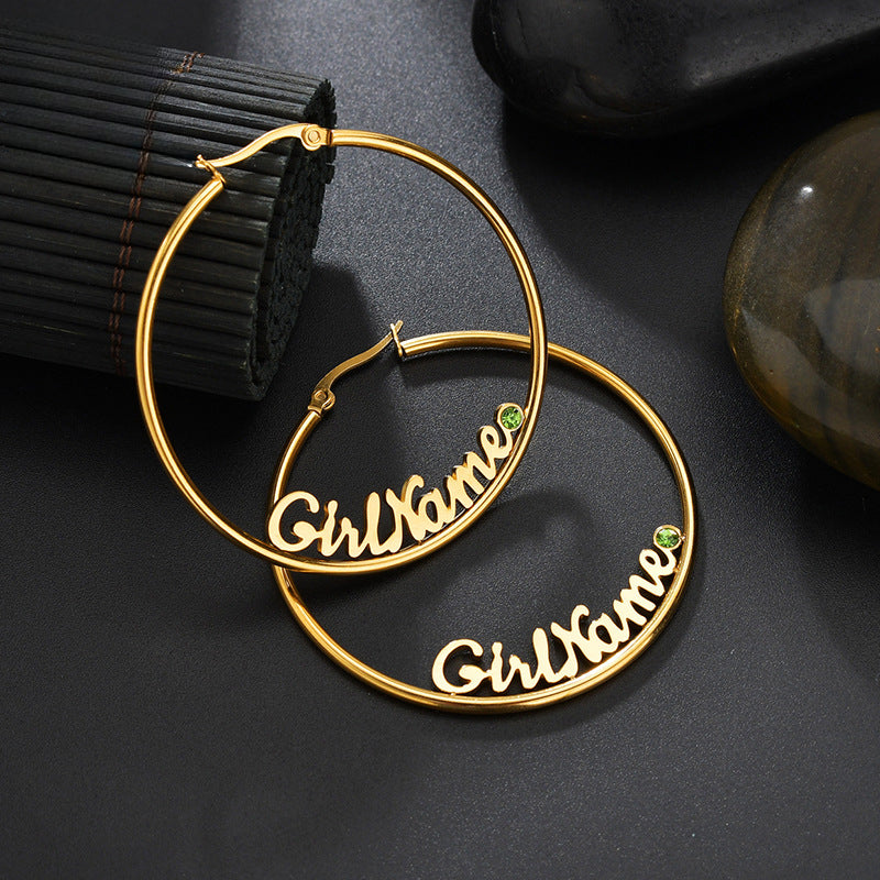 Hot-selling large round stainless steel letter name hoop earrings with rhinestone accents for women.
