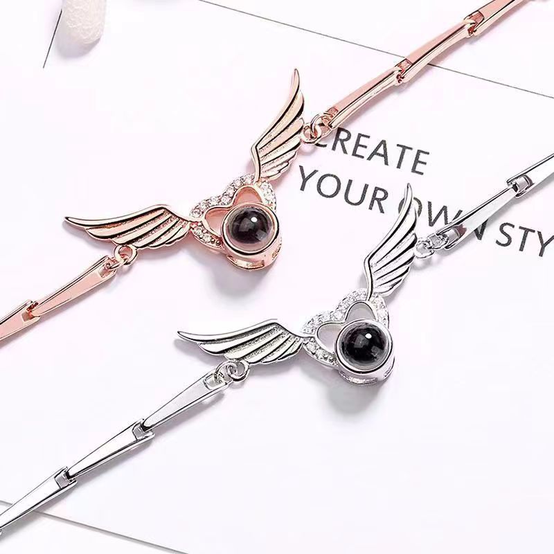 Hot-selling "I Love You" in 100 languages bracelet with crystal heart and wing design.