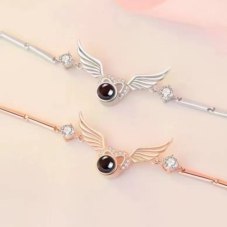 Hot-selling "I Love You" in 100 languages bracelet with crystal heart and wing design.