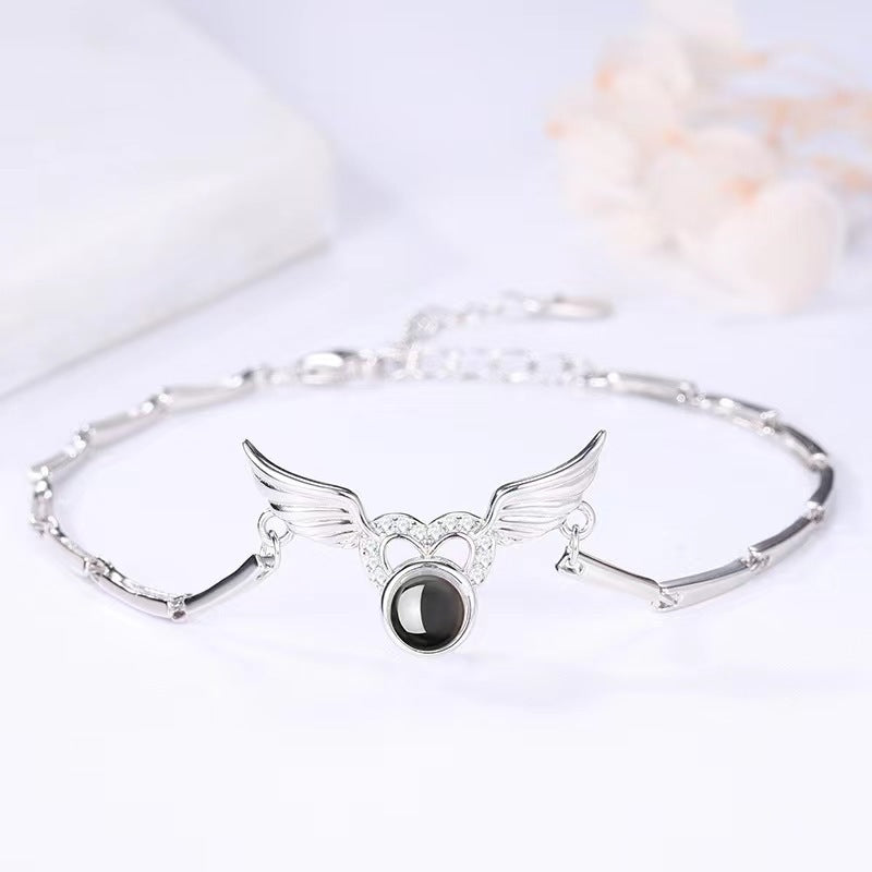 Hot-selling "I Love You" in 100 languages bracelet with crystal heart and wing design.