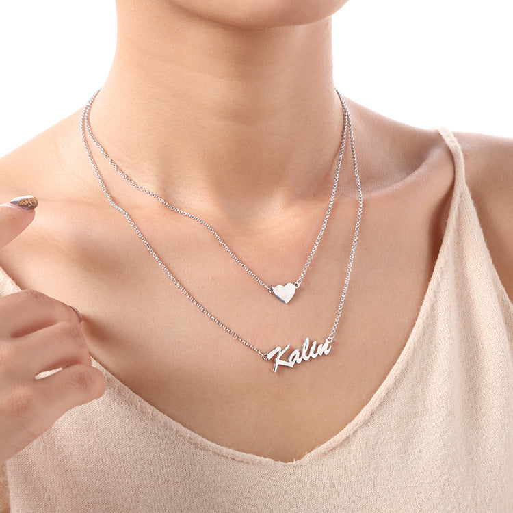 Custom heart-shaped double pendant necklace with personalized name lettering in silver. Stylish