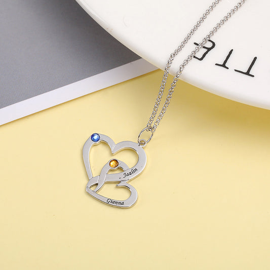 Customizable silver necklace features geometric heart shaped personalized name monogram and birthstones representing the twelve zodiac signs. Fashionable gift!