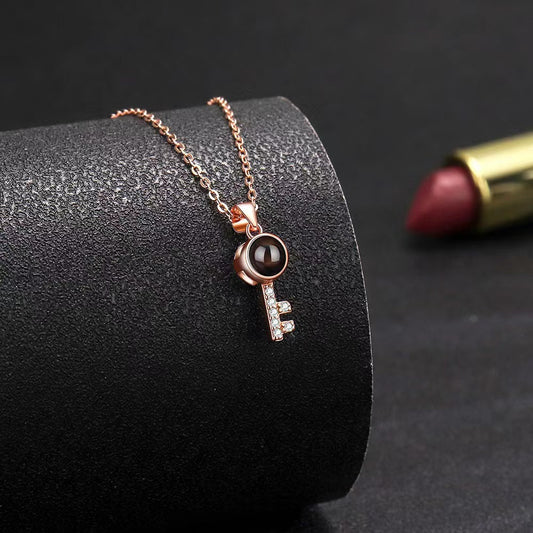 Diamond-encrusted key pendant necklace with photo projection and "I love you" in 100 languages, stylish design.